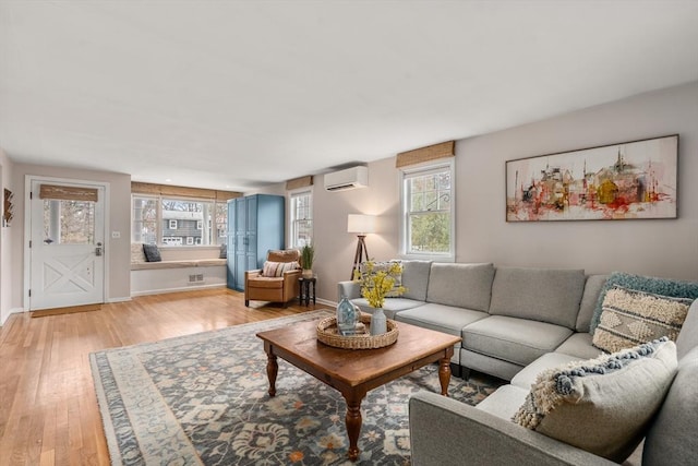 living room featuring light hardwood / wood-style flooring and a wall mounted AC