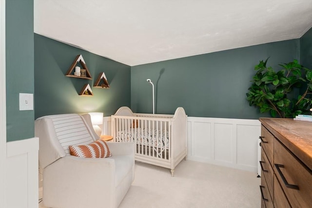 bedroom with a crib and light colored carpet