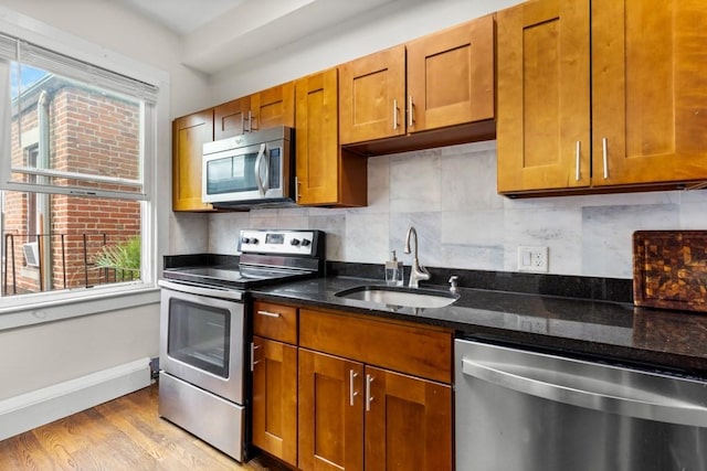 390 Riverway Unit 24, Boston, MA 02115 - kitchen featuring stainless steel appliances, a sink, plenty of natural light, and brown cabinets