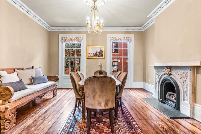 dining space with hardwood / wood-style floors, a chandelier, and ornamental molding