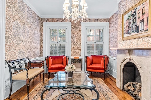 living area featuring hardwood / wood-style flooring, crown molding, and a notable chandelier