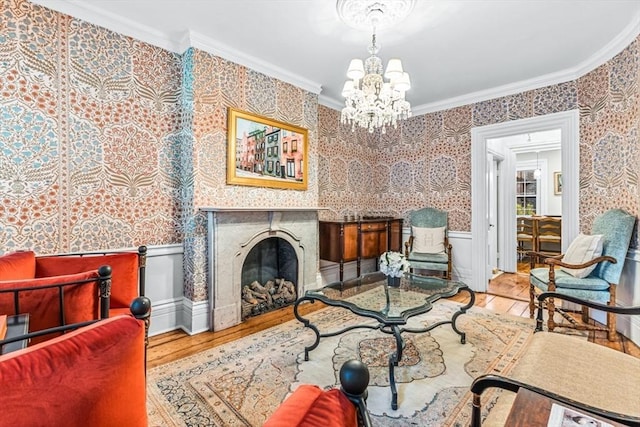 sitting room with hardwood / wood-style floors, a notable chandelier, and ornamental molding