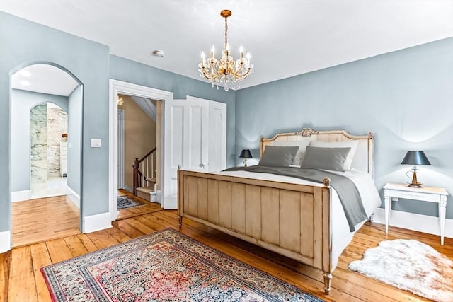 bedroom with hardwood / wood-style floors and an inviting chandelier