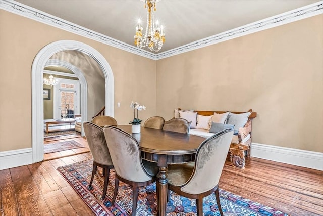 dining space with wood-type flooring and crown molding