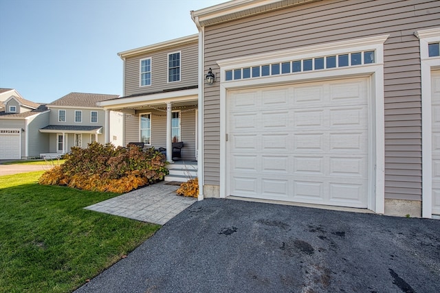 view of front of property featuring a garage, a front lawn, and a porch