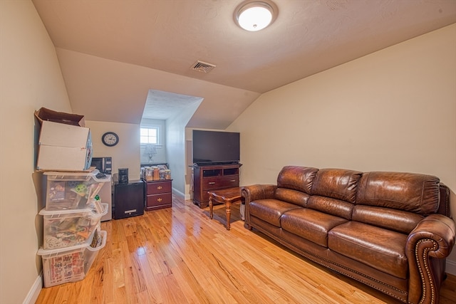 living room featuring vaulted ceiling and light wood-type flooring