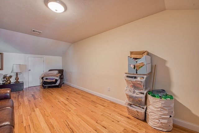 interior space featuring light hardwood / wood-style floors and vaulted ceiling