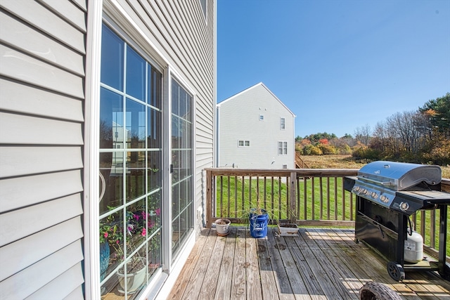 wooden deck with a yard and grilling area