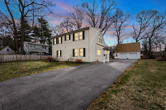 view of front of property with a garage, a lawn, and an outbuilding