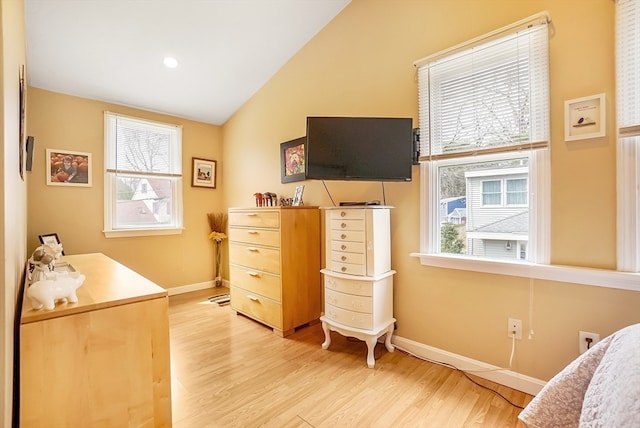 bedroom with light wood-type flooring and lofted ceiling