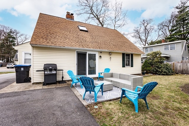 rear view of house with a lawn, outdoor lounge area, and a patio