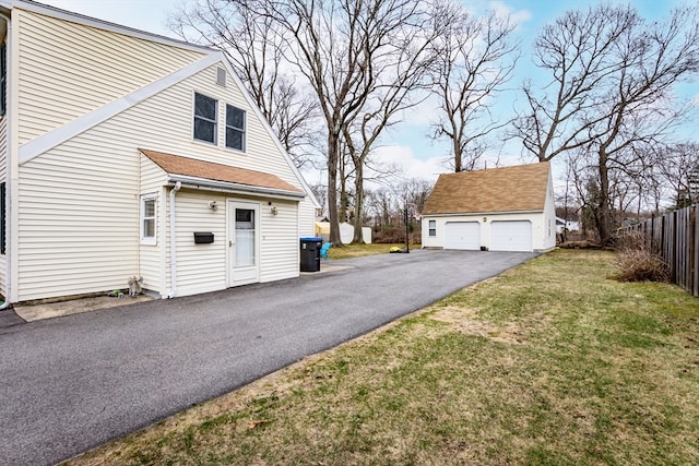 view of home's exterior featuring an outdoor structure, a lawn, and a garage