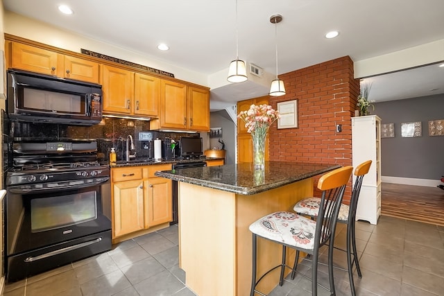 kitchen featuring decorative light fixtures, black appliances, light tile patterned flooring, a breakfast bar area, and decorative backsplash