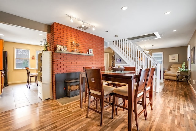 dining space with a wood stove and light hardwood / wood-style floors