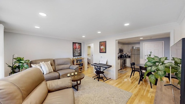 living room featuring recessed lighting, crown molding, and light wood-type flooring