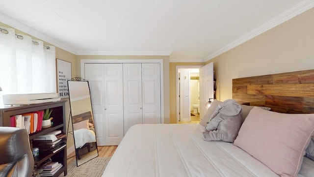 bedroom featuring light wood-type flooring, a closet, ensuite bath, and ornamental molding