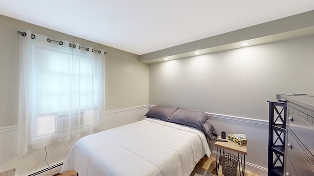 bedroom with recessed lighting, wood finished floors, and a baseboard radiator