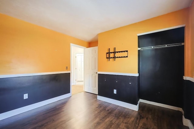 unfurnished bedroom featuring baseboards, a closet, and wood finished floors