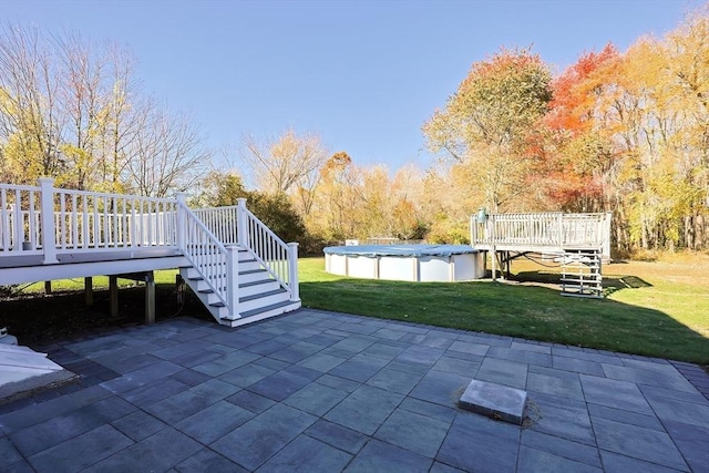 view of patio with a covered pool, stairs, and a wooden deck