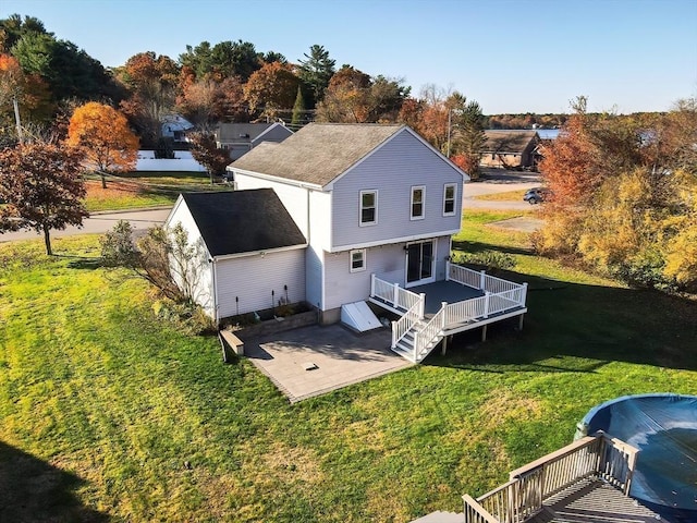 back of house featuring a patio area, a shingled roof, a lawn, and a wooden deck