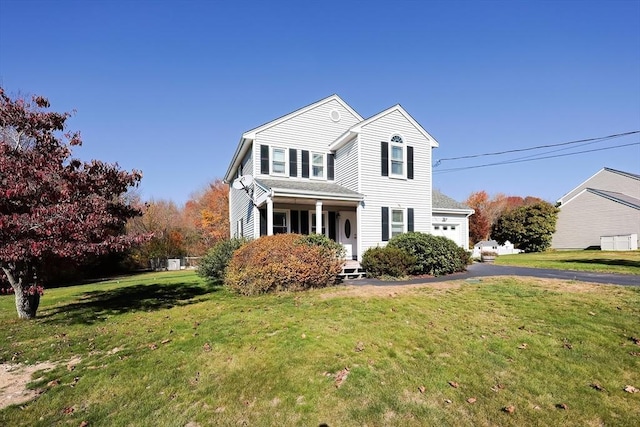 view of front of property featuring an attached garage and a front lawn