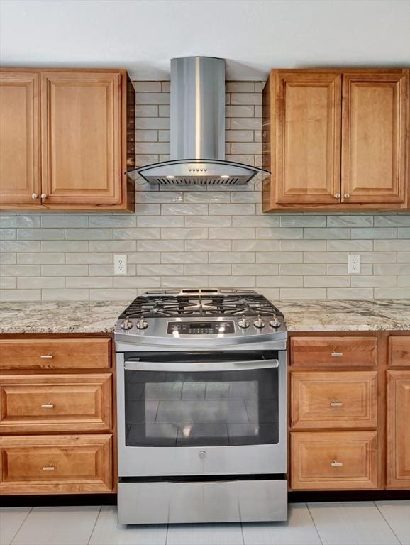 4 Gary Rd, Norton, MA 02766 - kitchen featuring stainless steel gas stove, wall chimney range hood, light tile patterned flooring, and light stone counters