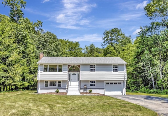 4 Gary Rd, Norton, MA 02766 - raised ranch featuring a chimney, driveway, a garage, and a front yard