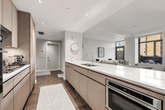 kitchen featuring appliances with stainless steel finishes, a sink, light countertops, open floor plan, and visible vents