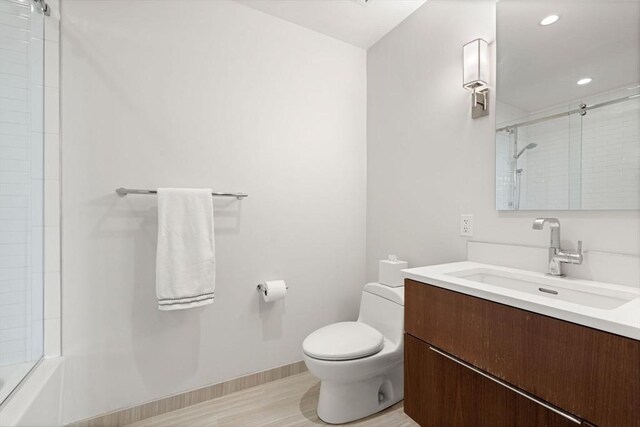 full bath featuring recessed lighting, vanity, baseboards, and toilet