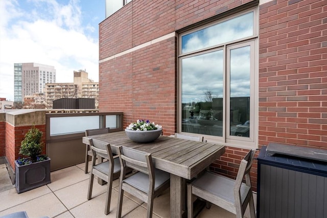 balcony featuring a city view, outdoor dining space, and a patio area