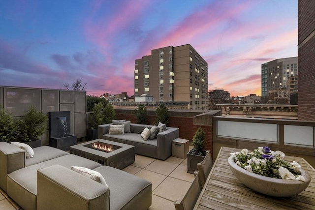 view of patio featuring a view of city and an outdoor living space with a fire pit