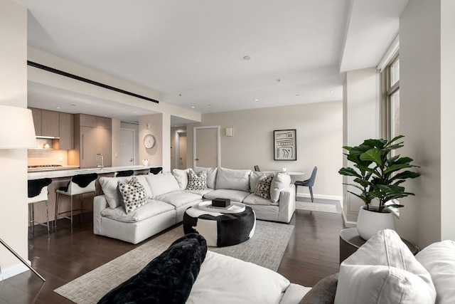 living room featuring dark wood-style flooring, baseboards, and recessed lighting