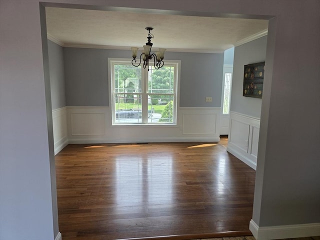 62 Saint Anthony St, Fitchburg, MA 01420 - unfurnished dining area with crown molding, a chandelier, wood finished floors, a wainscoted wall, and a decorative wall