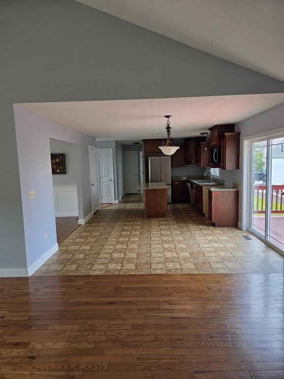 62 Saint Anthony St, Fitchburg, MA 01420 - kitchen with light wood finished floors, a center island, high vaulted ceiling, stainless steel appliances, and pendant lighting