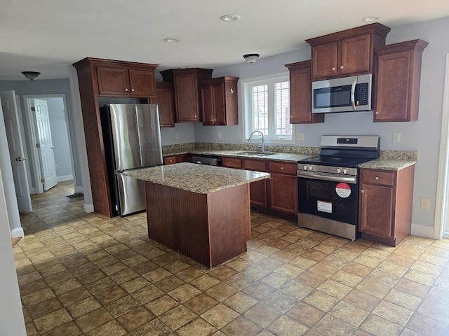 62 Saint Anthony St, Fitchburg, MA 01420 - kitchen featuring stainless steel appliances, light stone finish flooring, a kitchen island, light stone countertops, and recessed lighting