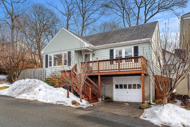 view of front of property featuring stairs, driveway, roof with shingles, and an attached garage