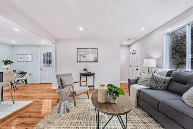 living area with recessed lighting, light wood-type flooring, and baseboards