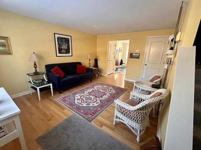 living room featuring a textured ceiling and light wood-type flooring