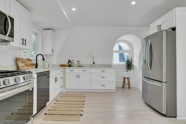 kitchen featuring sink, white cabinets, stainless steel appliances, and light hardwood / wood-style floors