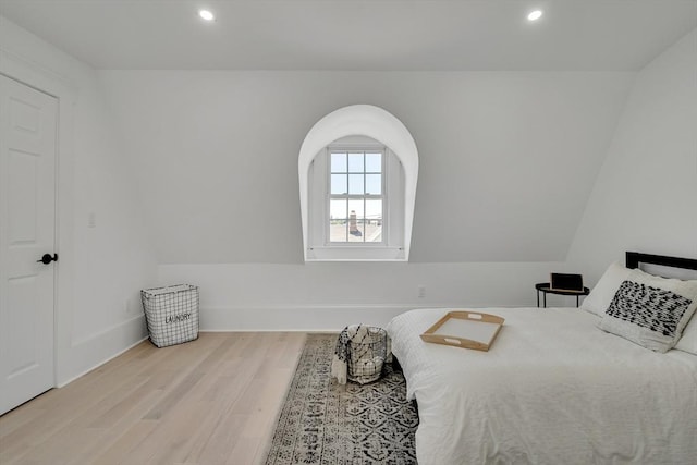 bedroom with vaulted ceiling and light hardwood / wood-style flooring