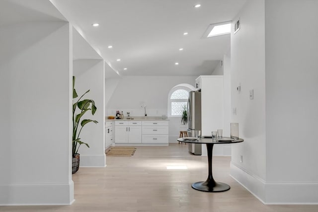 bathroom featuring wood-type flooring and a skylight