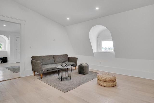 sitting room with plenty of natural light, light hardwood / wood-style floors, and lofted ceiling