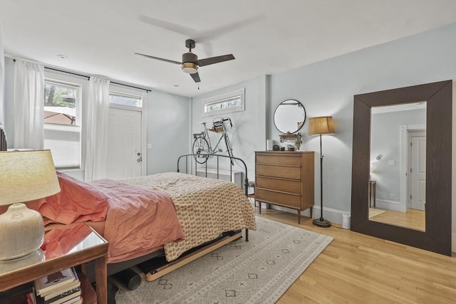 bedroom featuring baseboards, a ceiling fan, and light wood-type flooring
