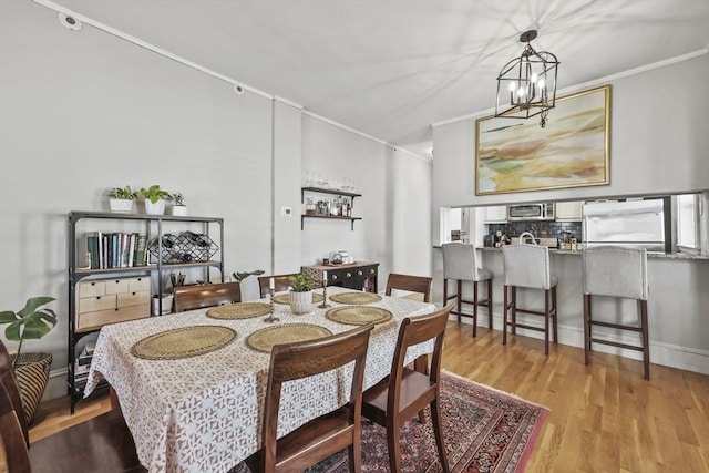 dining room featuring crown molding, a chandelier, and wood finished floors