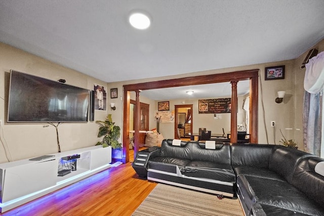 living room with ornate columns and hardwood / wood-style floors