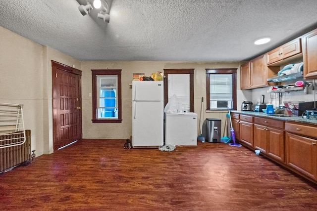 kitchen featuring dark hardwood / wood-style floors, white refrigerator, a textured ceiling, and cooling unit