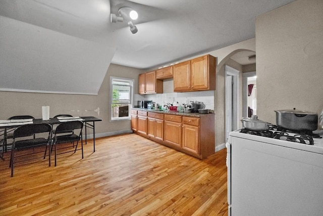 kitchen with white range with gas cooktop and light hardwood / wood-style flooring