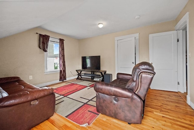 living room with vaulted ceiling and light wood-type flooring