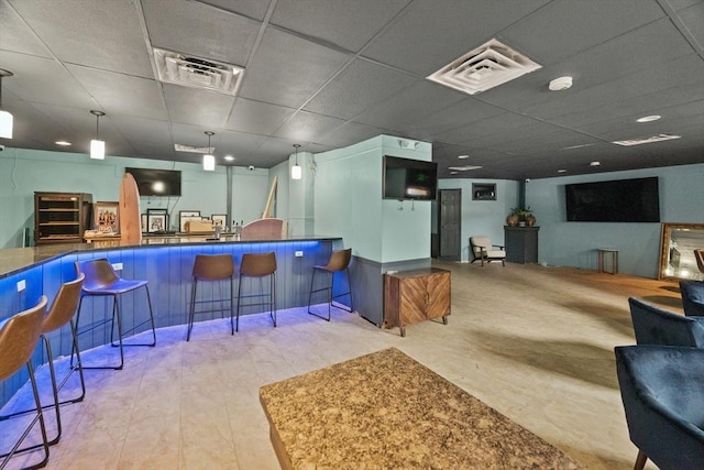 interior space featuring a paneled ceiling and hanging light fixtures