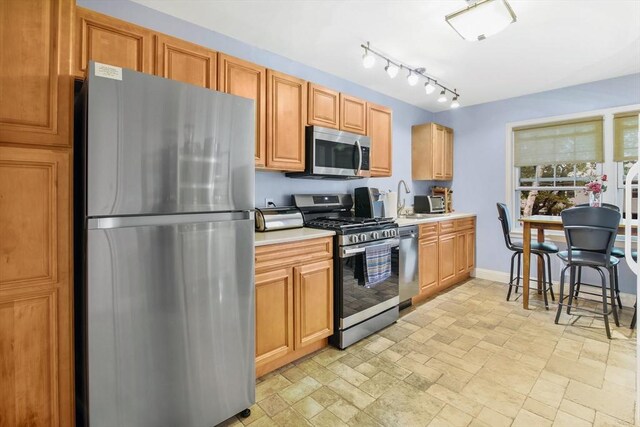 80 Brush Hill Ave Unit 33, West Springfield, MA 01089 - kitchen featuring appliances with stainless steel finishes, light countertops, light stone finish floors, baseboards, and a sink